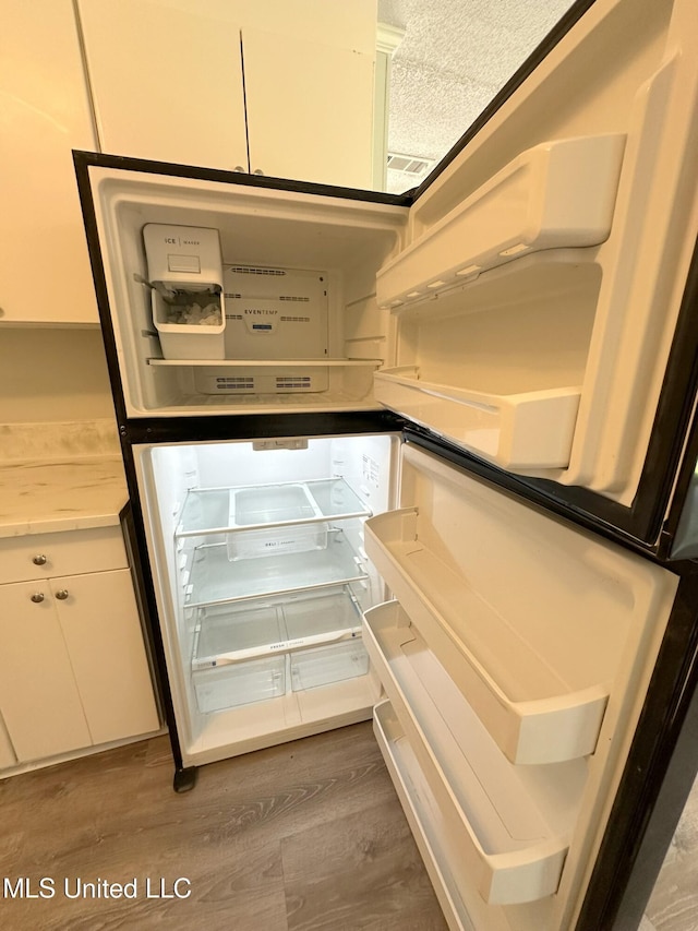 114 Leland St, Pearl, MS 39208 - interior details with white cabinets, light countertops, wood finished floors, and fridge