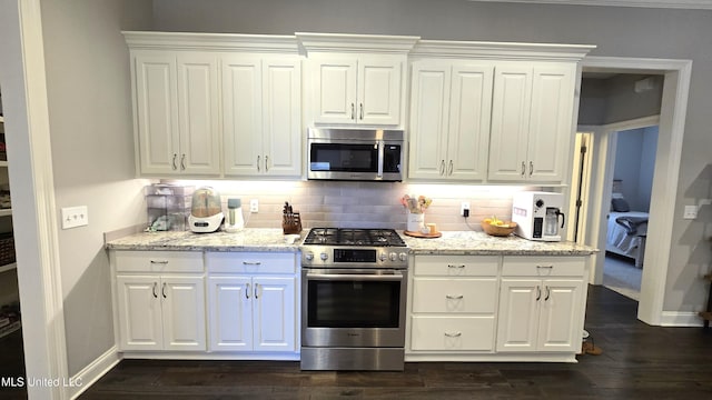 331 Emerald Way, Brandon, MS 39047 - kitchen featuring appliances with stainless steel finishes, tasteful backsplash, white cabinetry, and dark wood-style floors