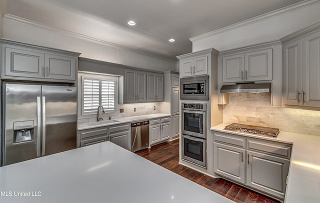 kitchen with dark hardwood / wood-style flooring, ornamental molding, sink, gray cabinets, and stainless steel appliances