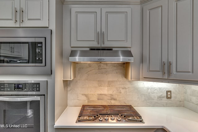 kitchen featuring appliances with stainless steel finishes, tasteful backsplash, and ventilation hood