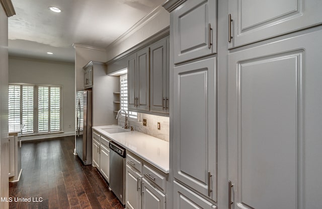 kitchen featuring dark wood-type flooring, stainless steel appliances, sink, crown molding, and gray cabinets