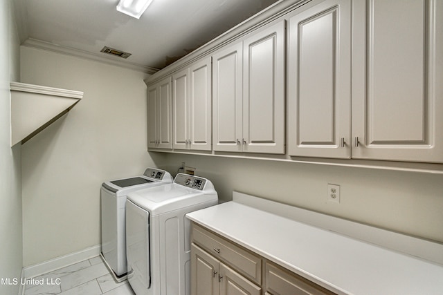 laundry area featuring ornamental molding, cabinets, and separate washer and dryer