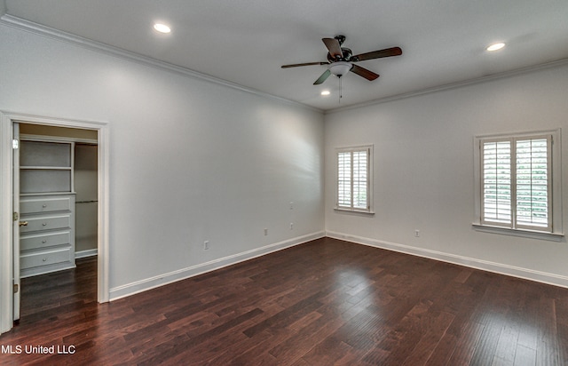 unfurnished bedroom featuring ceiling fan, crown molding, dark hardwood / wood-style flooring, and a walk in closet