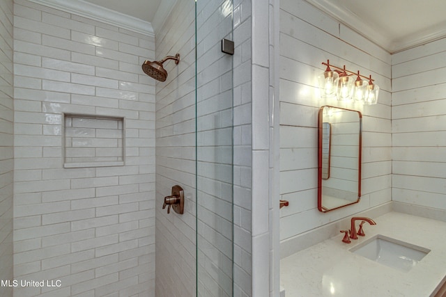 bathroom featuring vanity, ornamental molding, and tiled shower