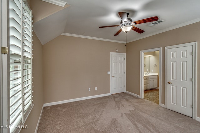 unfurnished bedroom with ornamental molding, vaulted ceiling, light carpet, and ensuite bath