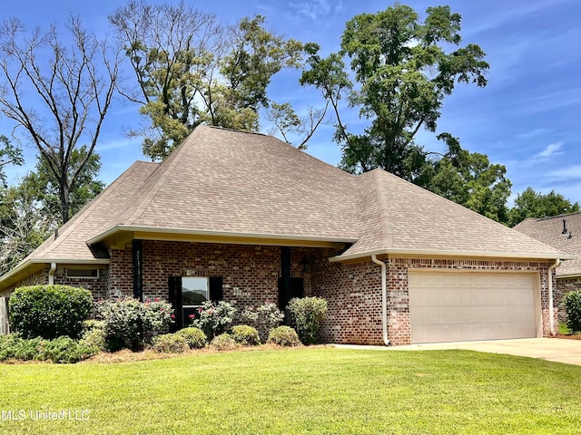 125 Rhodes Ln, Canton, MS 39046 - view of front of house featuring roof with shingles, a garage, brick siding, and a front lawn