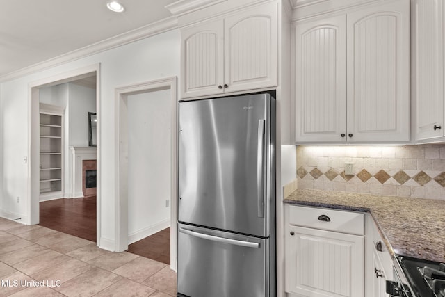 125 Rhodes Ln, Canton, MS 39046 - kitchen with stainless steel appliances, light tile patterned floors, decorative backsplash, a fireplace, and crown molding