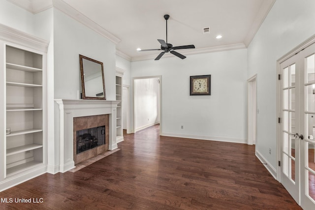 125 Rhodes Ln, Canton, MS 39046 - unfurnished living room featuring a tile fireplace, built in shelves, crown molding, dark wood finished floors, and ceiling fan