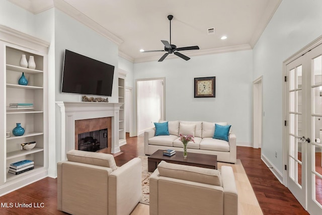 125 Rhodes Ln, Canton, MS 39046 - living room featuring ceiling fan, built in shelves, dark wood-type flooring, a fireplace, and ornamental molding