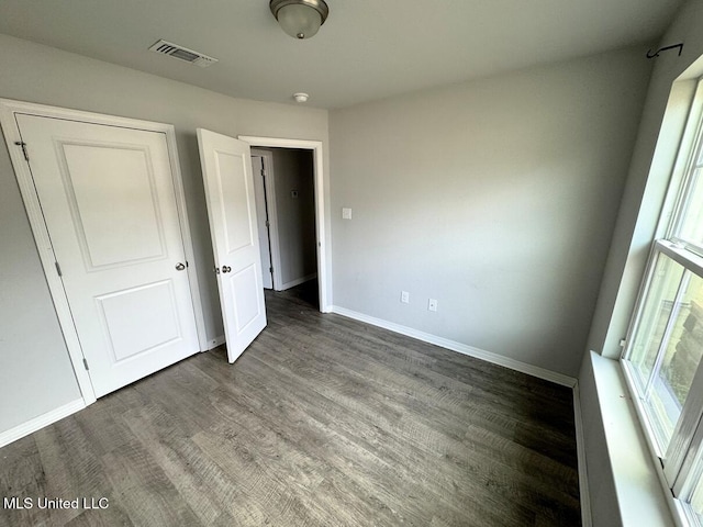 unfurnished bedroom with dark wood-type flooring