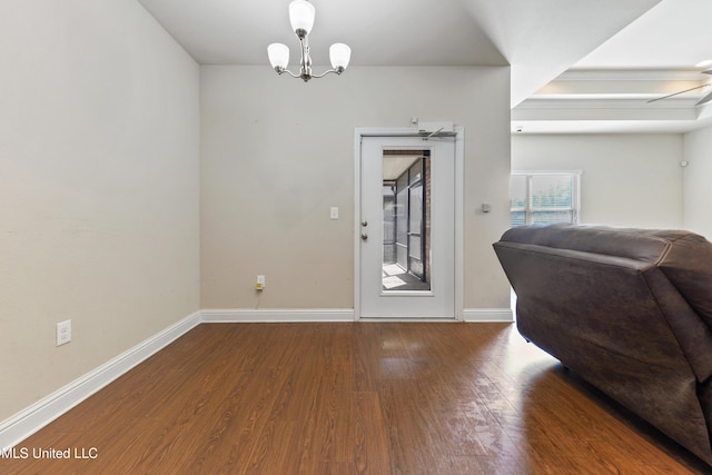 foyer with an inviting chandelier, baseboards, and wood finished floors