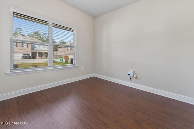 unfurnished room featuring dark wood-style floors and baseboards