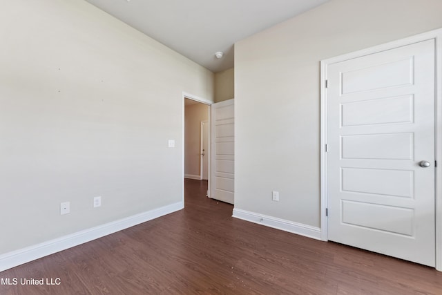 unfurnished bedroom featuring dark wood-style floors and baseboards