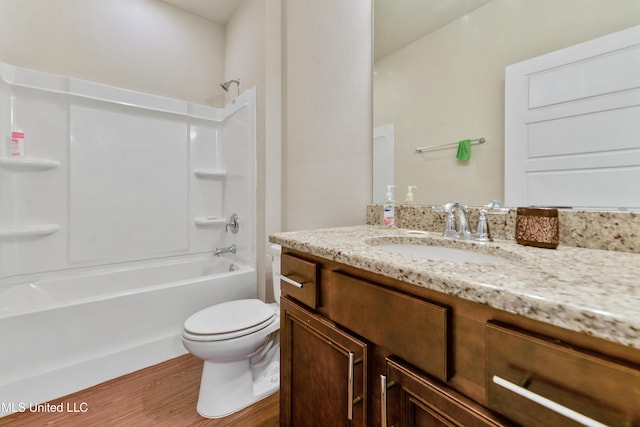 bathroom with toilet,  shower combination, wood finished floors, and vanity