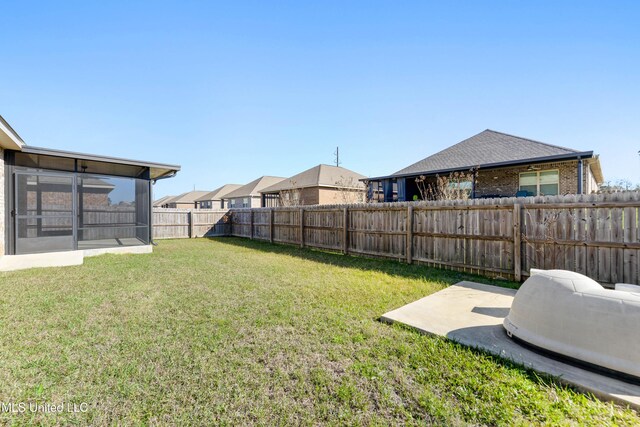 view of yard featuring a fenced backyard and a sunroom