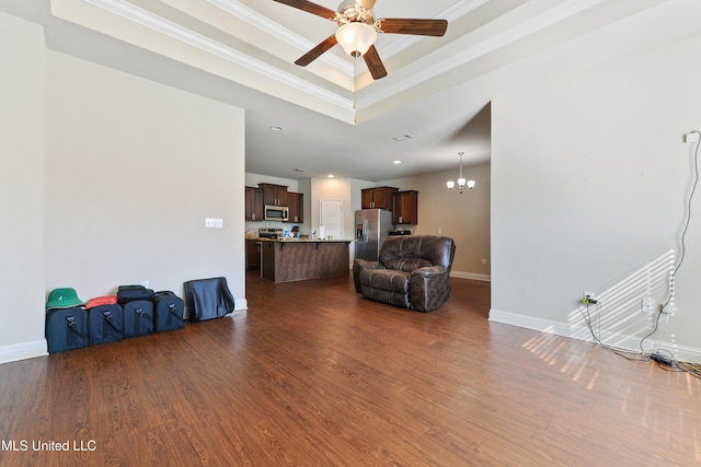 living area featuring crown molding, a raised ceiling, dark wood finished floors, and baseboards