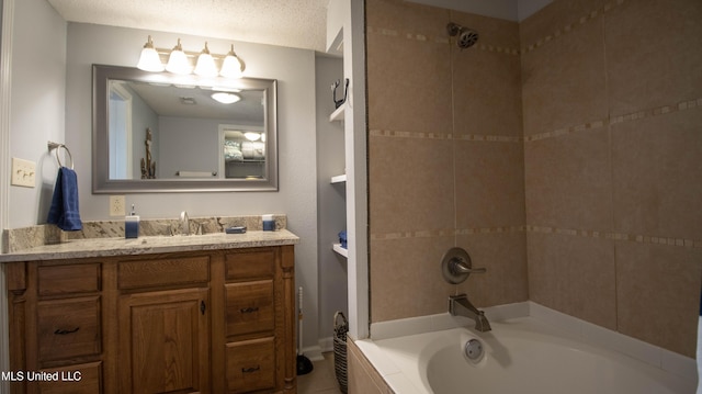 bathroom featuring tiled shower / bath combo, vanity, and a textured ceiling