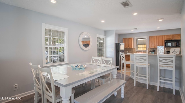 dining space with dark hardwood / wood-style floors and a wealth of natural light