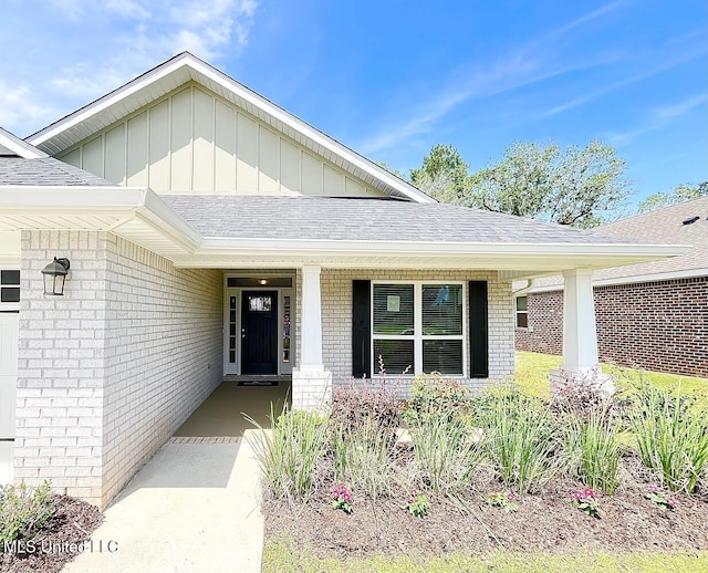 14007 Plantation Oaks Dr, Gulfport, MS 39503 - doorway to property featuring brick siding, board and batten siding, covered porch, and a shingled roof