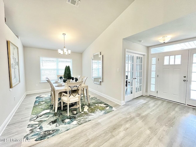 14007 Plantation Oaks Dr, Gulfport, MS 39503 - dining space featuring light wood-type flooring, lofted ceiling, a chandelier, plenty of natural light, and baseboards