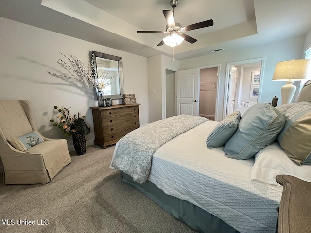 14007 Plantation Oaks Dr, Gulfport, MS 39503 - bedroom with a raised ceiling, light carpet, a walk in closet, ceiling fan, and ensuite bath