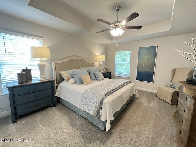 14007 Plantation Oaks Dr, Gulfport, MS 39503 - bedroom featuring a tray ceiling, light colored carpet, baseboards, and a ceiling fan