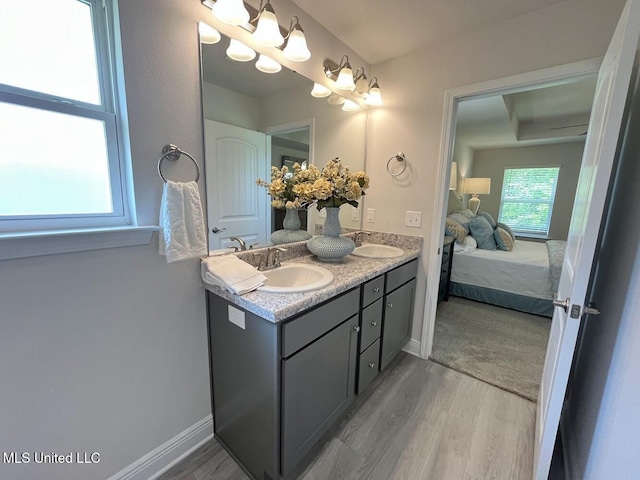 14007 Plantation Oaks Dr, Gulfport, MS 39503 - bathroom with double vanity, wood finished floors, ensuite bath, and baseboards