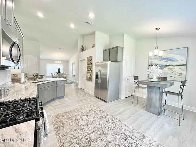 14007 Plantation Oaks Dr, Gulfport, MS 39503 - kitchen with appliances with stainless steel finishes, a chandelier, gray cabinetry, baseboards, and light wood-type flooring