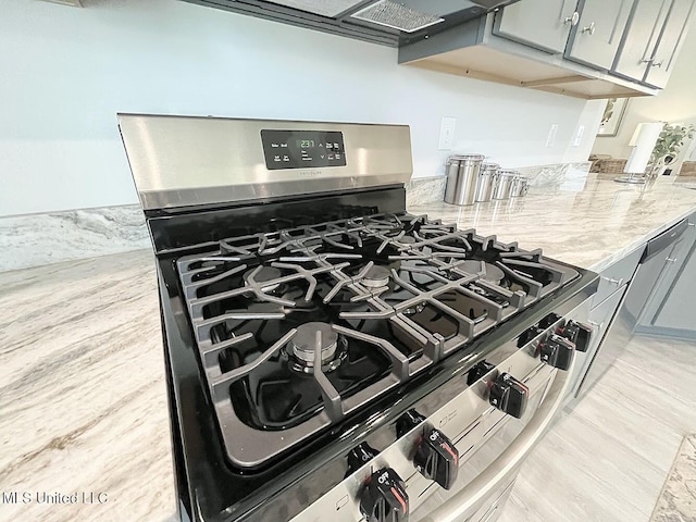 14007 Plantation Oaks Dr, Gulfport, MS 39503 - kitchen view of stainless steel range with gas cooktop, gray cabinetry, light stone countertops, and light wood-style flooring