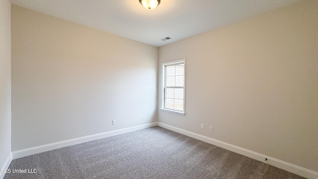 carpeted spare room featuring baseboards and visible vents