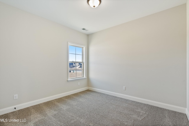 unfurnished room with carpet, visible vents, and baseboards