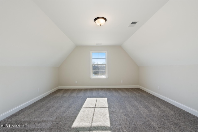 bonus room with dark carpet, visible vents, vaulted ceiling, and baseboards