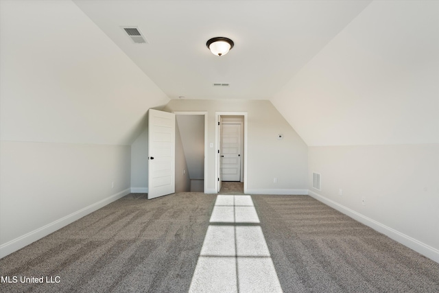 additional living space featuring lofted ceiling, baseboards, visible vents, and carpet flooring