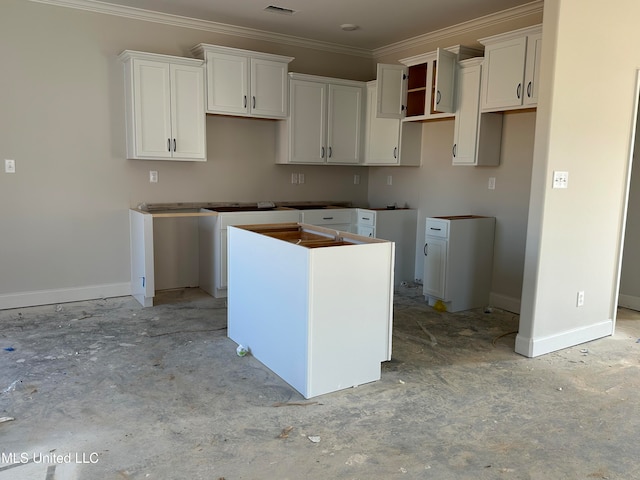 kitchen featuring white cabinets, crown molding, visible vents, and baseboards