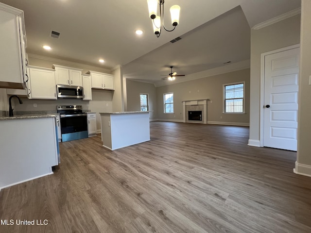 kitchen featuring visible vents, appliances with stainless steel finishes, open floor plan, white cabinetry, and a kitchen island