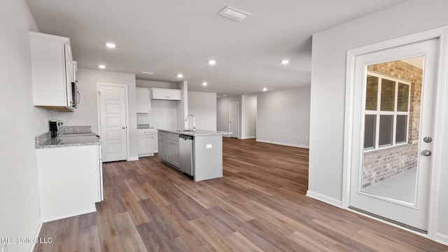 9613 Reserve Blvd, Biloxi, MS 39532 - kitchen with appliances with stainless steel finishes, an island with sink, white cabinetry, dark wood-type flooring, and recessed lighting