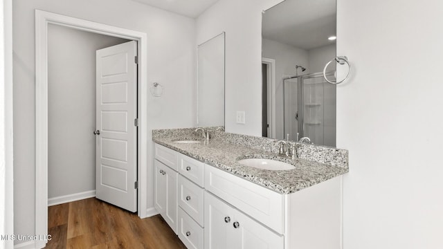 9613 Reserve Blvd, Biloxi, MS 39532 - bathroom featuring double vanity, a stall shower, and wood finished floors