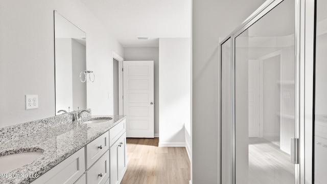 9613 Reserve Blvd, Biloxi, MS 39532 - full bath with wood finished floors, double vanity, and an enclosed shower