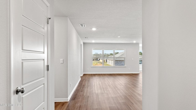 9613 Reserve Blvd, Biloxi, MS 39532 - hallway with wood finished floors, a textured ceiling, and recessed lighting