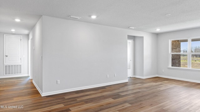 9613 Reserve Blvd, Biloxi, MS 39532 - empty room with wood finished floors, a textured ceiling, and recessed lighting