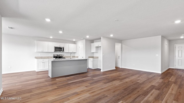 9613 Reserve Blvd, Biloxi, MS 39532 - kitchen with stainless steel appliances, open floor plan, an island with sink, white cabinets, and recessed lighting