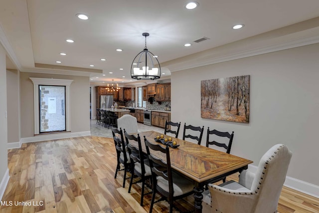 11281 Rd 468, Philadelphia, MS 39350 - dining space featuring crown molding, a chandelier, and light hardwood / wood-style flooring
