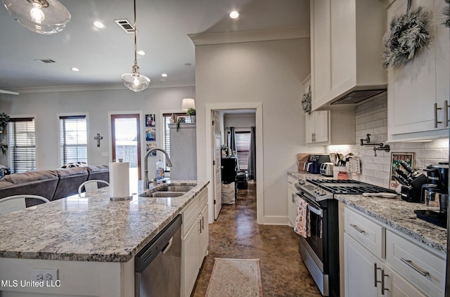 kitchen featuring stainless steel appliances, tasteful backsplash, visible vents, a sink, and premium range hood