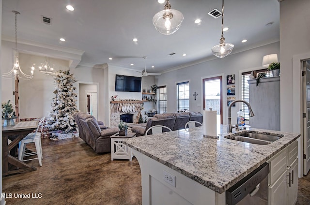 kitchen featuring dishwasher, a fireplace, a sink, and visible vents