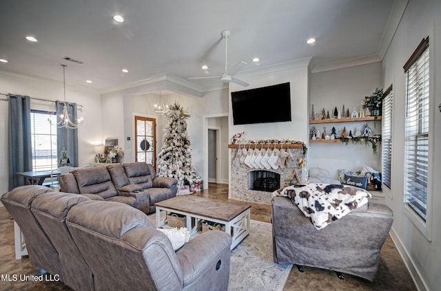 living room with a stone fireplace, recessed lighting, visible vents, and crown molding