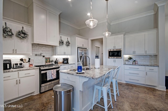 kitchen with appliances with stainless steel finishes, white cabinets, a sink, and crown molding