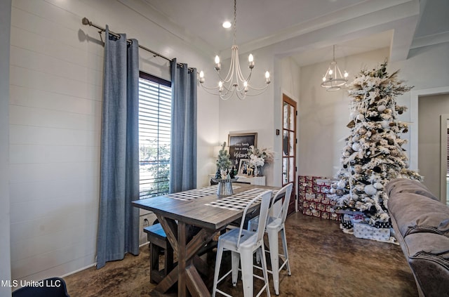 dining room featuring concrete floors and a notable chandelier