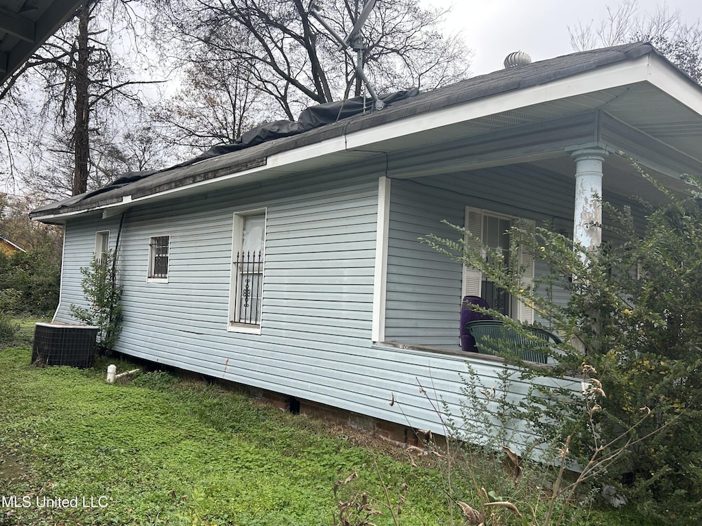 view of home's exterior with central AC unit and a lawn