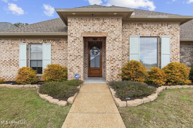 view of exterior entry featuring a yard