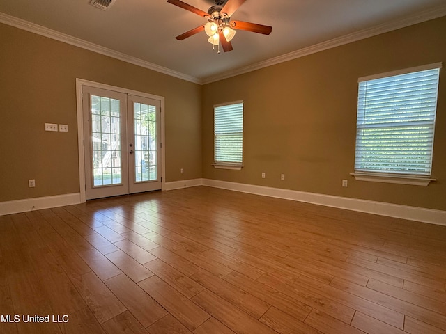 spare room with crown molding, french doors, ceiling fan, and light wood-type flooring